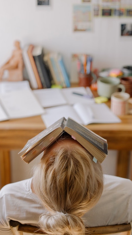 woman balancing book on her head learning how-to-manifest-passing-an-exam